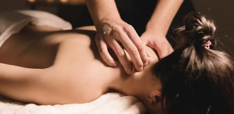 Pressure applied by a therpaist to the neck of a woman during a spa massage.